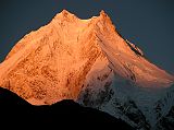 Manaslu 07 01 Manaslu Sunrise From Syala I waited with anticipation for the sun to rise and hit the mountains. Wow! The subtle changes of the light on Manaslu are terrific, turning from grey to pink to orange to yellow and then to white, all within a few minutes.